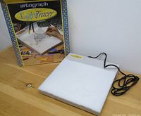 Artograph LightTracer light box with original packaging on wooden surface