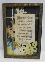 Framed picture featuring "Common Sense is good to have" poem with floral background in carved wood frame.