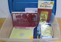 Plastic tub with a red plastic embossing stencil with Christmas theme, other paper stencil packs including one labeled 'Emma's Collection'