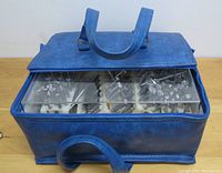 Blue zippered tool bag with clear lid containing foam trays of metal stamping dies