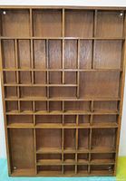 Front view of the wooden letterbox shelf unit showing vertical orientation with multiple compartments of different sizes.