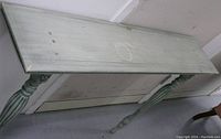 Full view of long rectangular wooden side table with two carved legs, showing worn bluish-green painted finish.