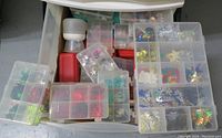 Top drawer with small plastic boxes filled with beads, sequins, and star shapes