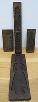 Front view of the wooden cookie moulds showing detailed carved figures and windmill designs on four moulds.