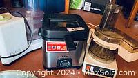T-Fal oil fryer, electric food processor, mini food processor and white appliance on wooden surface