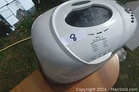 Top and side view of white Black & Decker bread maker showing control panel and viewing window