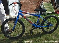 Side view of the child's Movelo bicycle showing frame, wheels, pedals, saddle, handlebar grips, and brake cables.