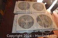 Two electric double window fans stacked on one another, showing size and design.