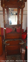 Front view of tall wooden tree stand with mirror and umbrella holder showing overall condition and structure.