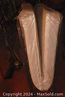 Photo of the folded cot still in plastic, shows the twin size cot folded in half for storage.