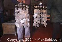 Photo showing two hanging circular chandeliers decorated with strands of round Capiz shells.