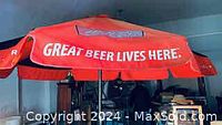 Red patio umbrella with Miller beer branding showing slogan 'GREAT BEER LIVES HERE'