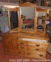 Full front view of the maple dresser showing six drawers, one cabinet and tri-fold mirror attached on top.