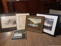 Five framed artworks shown together including paintings, drawings, and a photograph.