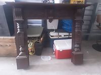 Full view of the carved wood fireplace mantle showing overall structure and bases.