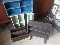 Five wooden crates of different sizes, one with legs, shown arranged on floor near wooden furniture.