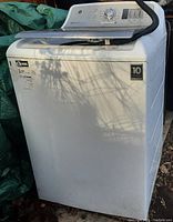 Front and right side view showing exterior condition, GE logo, warranty stickers