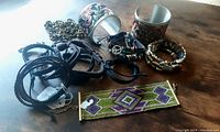 Assortment of costume jewelry on wooden surface including bracelets and necklaces.