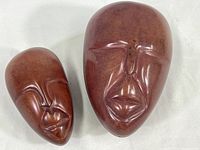 Two ceramic trinket boxes shaped like African tribal masks with reddish-brown finish, placed side by side on white background.