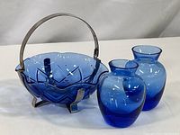 Overview of blue cobalt glass candy dish with metal bracket handle and two small blue glass bud vases.