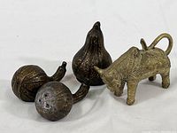 Overview of the four items together: two brass gourd salt and pepper shakers, one brass gourd figurine, and one metal bull figurine.