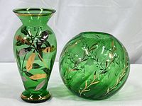 Photo showing two green glass vases, one round and one taller, both with hand painted gold vines and white berries.