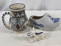 Three decorative ceramic items on white background: Tunisian jug, Dutch shoe pot, Christmas ornament.