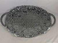 Full top view of large silver plated Lenox serving tray showing basket weave pattern and grape leaf border with handles