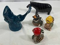 Group of five figurines showing whale, zebra, and three ceramic birds in colors red, yellow, and black