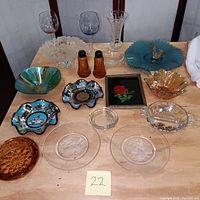 Full display of crystal, art glass, souvenir bowls, stemware, and tableware items arranged on table.