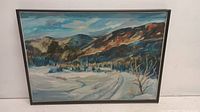 Full view of the framed winterscape oil painting featuring snowy landscape, village and hills.