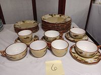 Full view of Stangl White Dogwood set including multiple dinner plates, dessert plates, cups, saucers, and bowls arranged on table