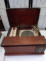 Open front view of vintage VM portable stereo turntable showing wooden hinged lid, platter, tonearm, and control knobs