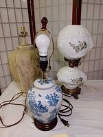 Three vintage table lamps displayed together showing various styles and materials.