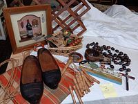 Photo of the collection showing carved wooden shoes, woven purse, bamboo chimes, wooden beads, wooden carved items in basket, and wine-themed shadow box