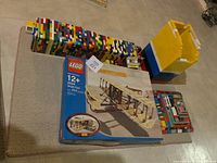 Overhead view of multicolored Lego tower with yellow, blue, white roof cap and Wright Flyer set box nearby