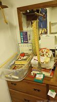 Photo showing sewing grid rulers, pincushion, wooden ruler and assorted items on a dresser