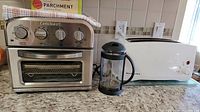 Cuisinart toaster oven, KitchenAid toaster, and large French press on kitchen counter