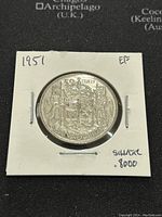Obverse side of the 1951 Canadian silver 50 cents coin showing the Canadian coat of arms with details and inscriptions including '50 CENTS' and 'CANADA'. Coin in white holder labeled '1951 EF Silver 8000'.