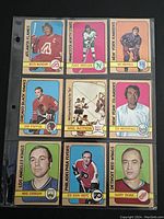 Front view of nine 1972-3 O-Pee-Chee NHL hockey trading cards arranged in three rows and three columns in a plastic sleeve. Cards show portraits and action images with player names and team logos.