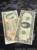 Both banknotes laid out on a black world map background showing the front sides of the 1979 Canadian $20 bill with Queen Elizabeth II portrait and 1981 US $20 bill with Andrew Jackson portrait.