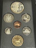 Obverse side of coins showing Canadian wildlife and traditional images including a large $1 double dollar coin with Hudson's Bay Company theme.