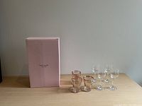 All glassware items including 4 clear wine glasses, 3 striped vintage glasses with gold rims, and 2 Kate Spade champagne flutes with pink box