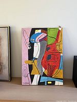 Front view of unframed abstract mid-century modern painting leaning on shelf