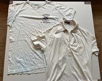 Front view of vintage University of Waterloo white t-shirt and vintage Roger Bresson Paris white polo shirt laid flat on surface.