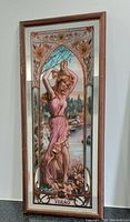 Frontal photo of the antique Art Nouveau painted mirror showing the detailed artwork of the woman in pink dress and floral motifs within a wooden frame.