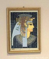 Front view of framed Egyptian papyrus artwork of Queen Cleopatra showing full artwork and gold frame.