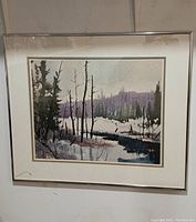 Framed print showing full artwork with visible winter river and trees, snow on ground, signed by artist on bottom right.