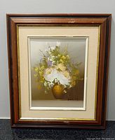 Framed oil painting on canvas depicting flowers in a golden vase with signature 'Park SH' visible. The frame is wooden with a beige matting. Minor frame wear visible.
