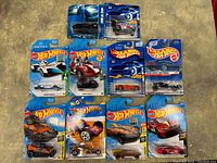 Group of 10 Hot Wheels toy cars in original blister pack with some packaging slightly altered but still sealed.